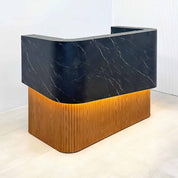 72-inch Nola Curved Custom Reception Desk in black traceless laminate counter, maple tambour bottom, and warm white LED.