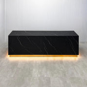 122-inch Houston Custom Reception Desk with Black Stone Palazzo matte laminate Top, Black Stone Palazzo matte laminate Main Desk, Gold aluminum Toe-Kick, and warm white LED.