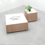 36-inch Norfolk Square Lobby Table with white matte laminate top and discontinued white oak tambour side table.