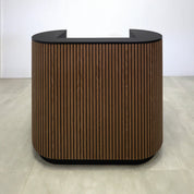 48-inch The Pill X2 Podium & Host Custom Desk with Walnut Tambour and Black background main body. Black Traceless laminate workspace and Top. Black Traceless laminate toe-kick.