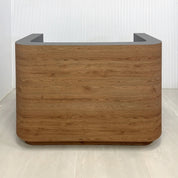 60-inch Nola Custom Reception Desk with Spiced Chestnut 1517 matte laminate front and Toe-Kick. Storm Gray matte laminate workspace and White LED. 