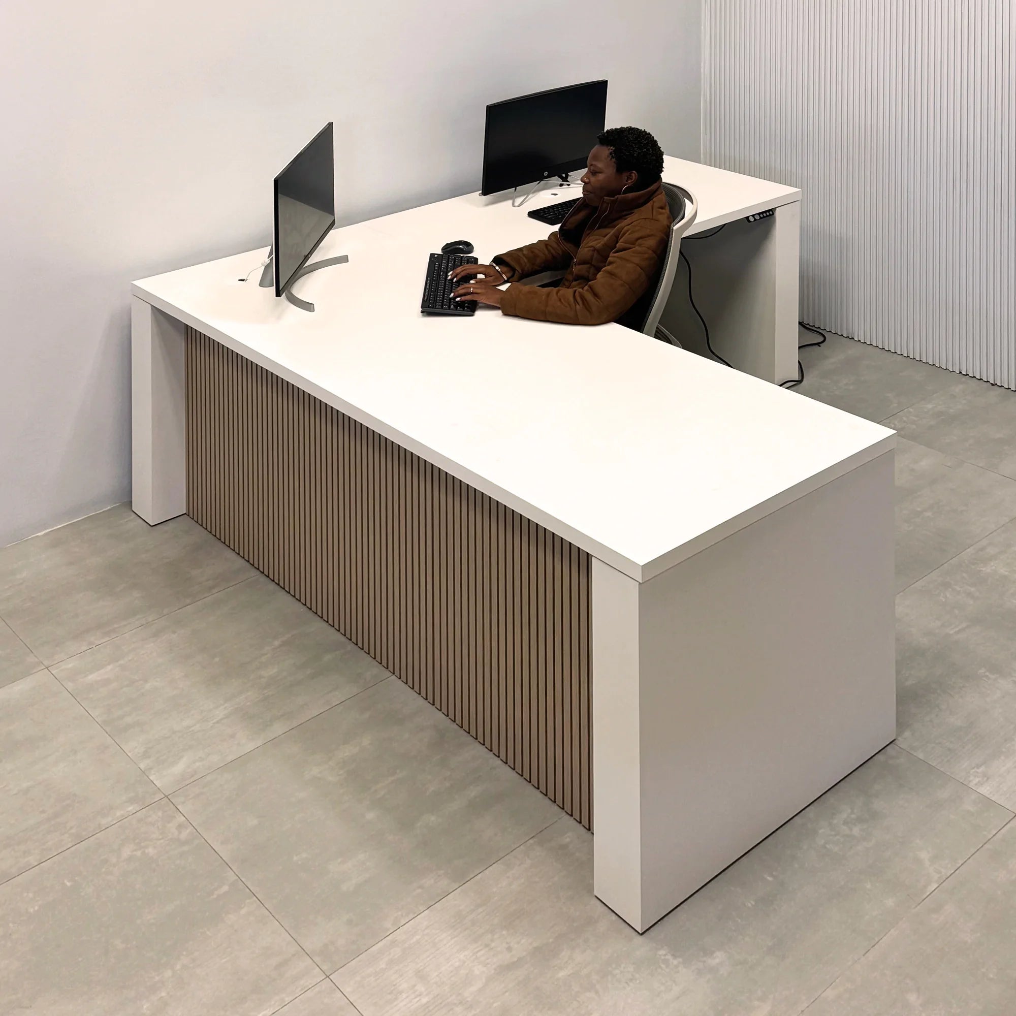 80-inch Denver L-Shape Laminate Executive Desk with Sit-Stand Mechanism with Dover Off-White matte laminate top and base. Washed Oak tambour privacy panel and white base.