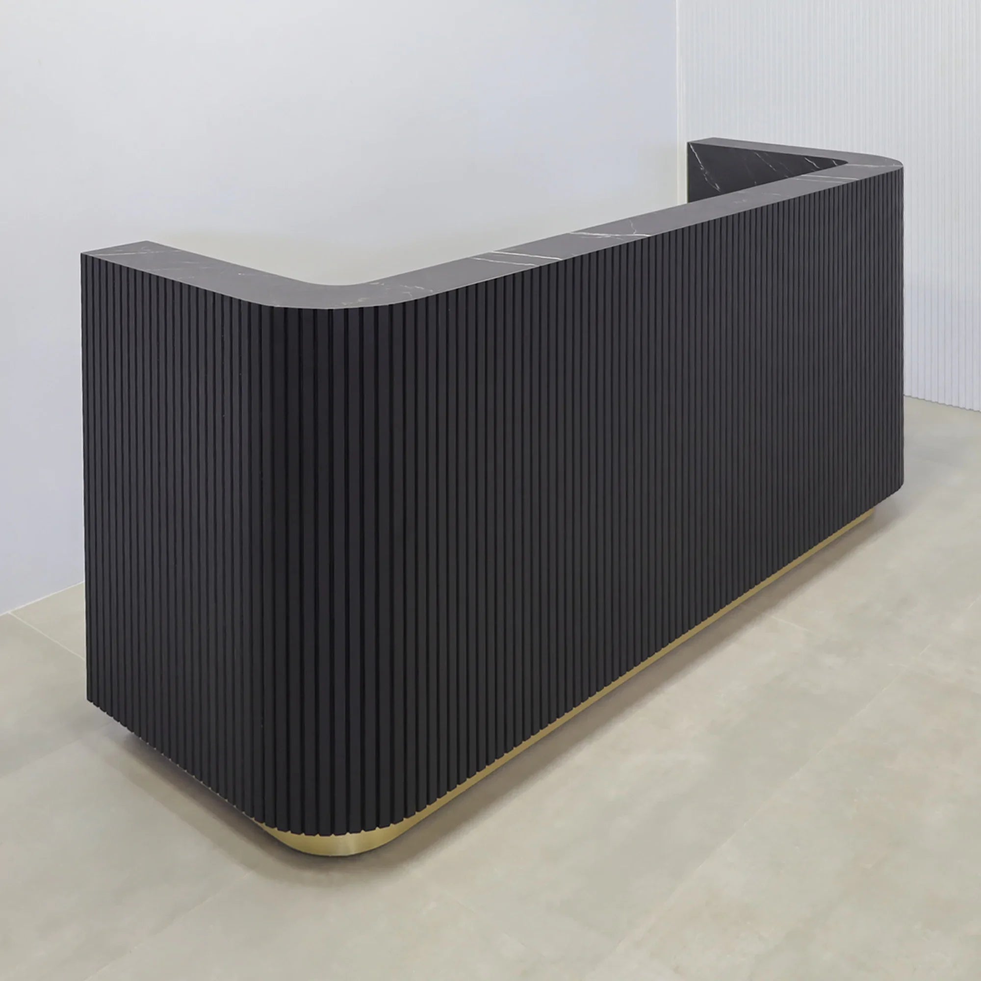 90-inch  Nola Custom Reception Desk with Black Traceless Tambour main desk, and Black Stone PVC laminate workspace. Gold aluminum toe-kick, and warm white LED. 
