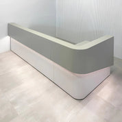 120-inch Nola L-Shape Curved Custom Reception Desk with folkstone gray matte laminate counter, white matte tambour bottom, white matte laminate workspace, with white LED.